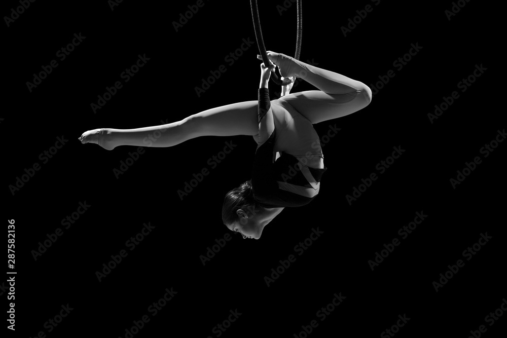 Obraz premium A female gymnast performing exercises on an air ring (hoop)