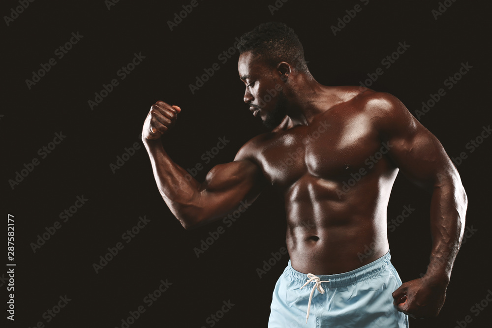 Hot african bodybuilder demonstrating his arm strength