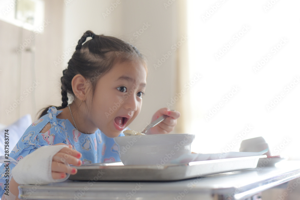 Patient child eating food in hospital bed Patient child eating food in hospital bed