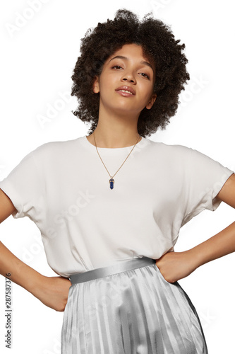 The medium front shot of a young mulatta lady with a golden chainlet with a pendant in the form of screw with a fitted-in deep blue gemstone similar to a lazulite on her neck.  photo