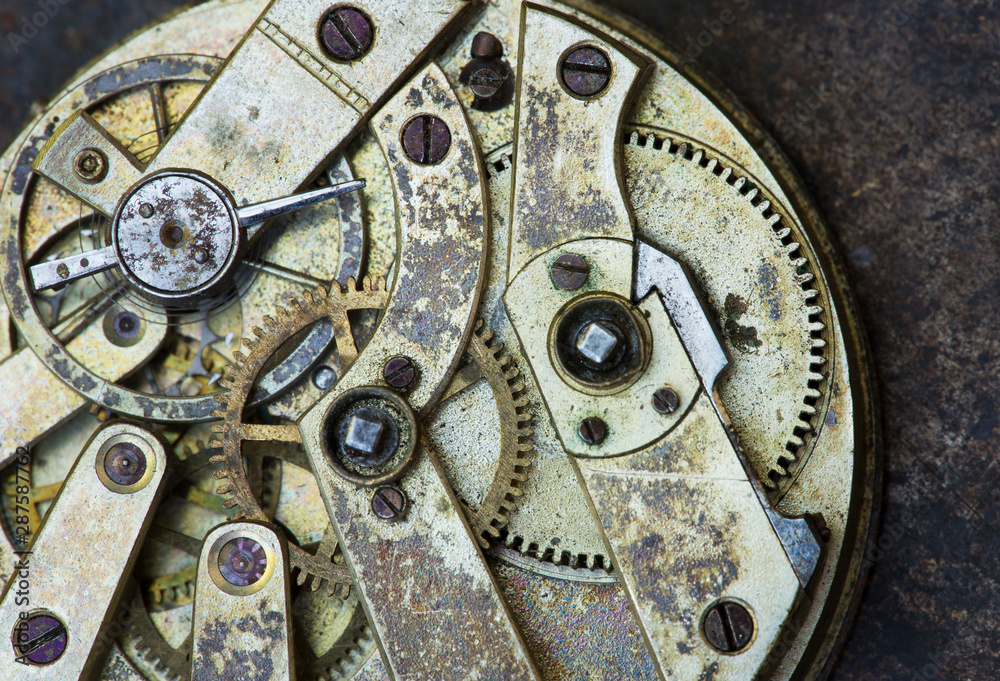 Gears of a vintage metal business clock watch close-up background, time mechanism, timing concept