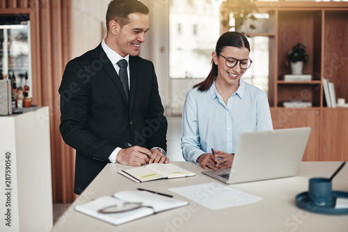 Two smiling businesspeople working together in an modern office