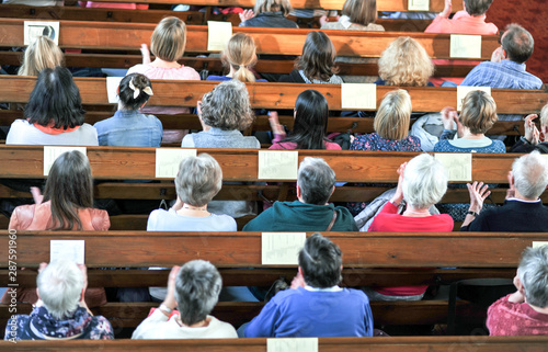 Draufsicht auf eine christliche Gemeinde bei einem Gottesdienst oder Konzert in einer Kirche â€“ selektiver Fokus, BewegungsunschÃ¤rfe beim Klatschen photo