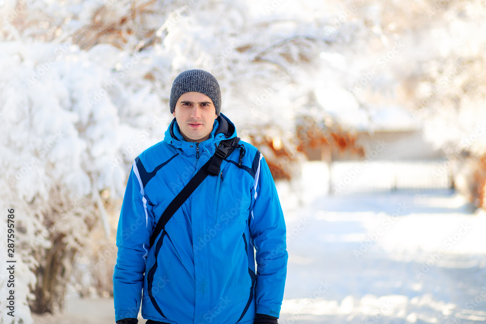 Winter portrait of young man in a beautiful snowy winter park Winter portrait of young man in a beautiful snowy winter park