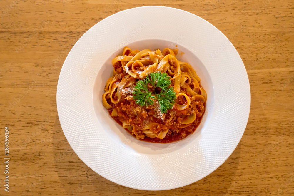 Spaghetti with white disc on wooden table Spaghetti with white disc on wooden table