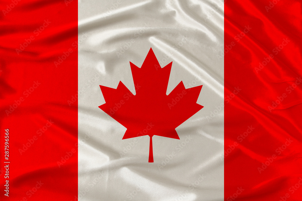 Obraz premium Canada national flag on gentle silk with wind folds, travel concept, immigration, politics