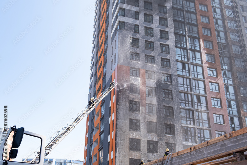 Fototapeta premium fireman climbing a ladder with water hose for extinguish fire