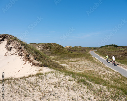 people enjoy nature by riding bicycle on the german island of norderney on sunny summer day in august