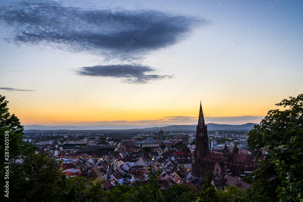 Germany, Beautiful city freiburg im breisgau in warm orange sunset atmosphere seen from above in summer