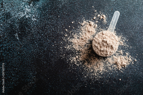 Top view whey protein scoop on dark background, copy space photo