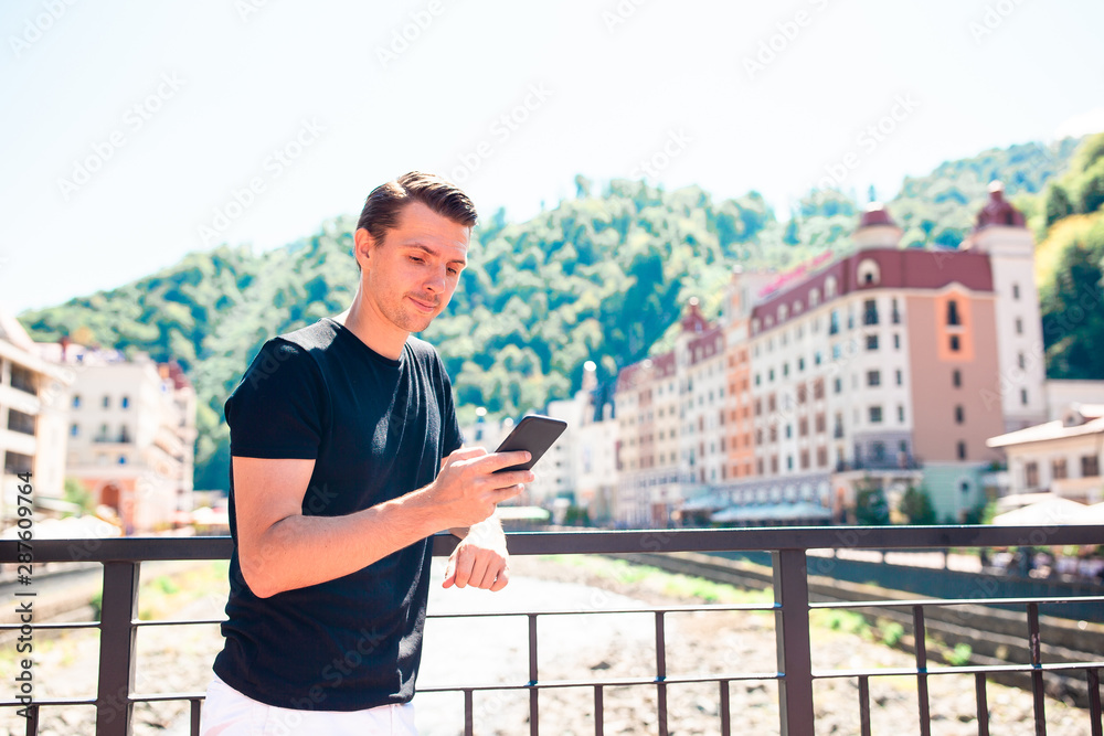Fototapeta premium Man on the embankment of a mountain river in a European city.