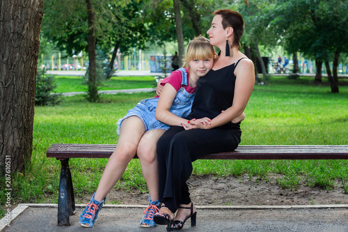 Mother and daughter sitting on a bench in the Park