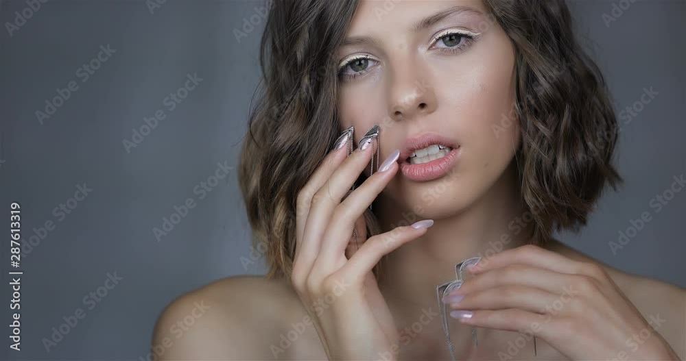 Attractive young girl with NailArt . beautiful girl with perfect skin and amazing manicure with decorations.