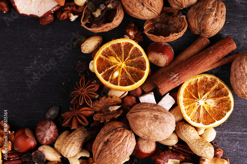 Composition with dried fruits and assorted healthy nuts on rustic background for christmas