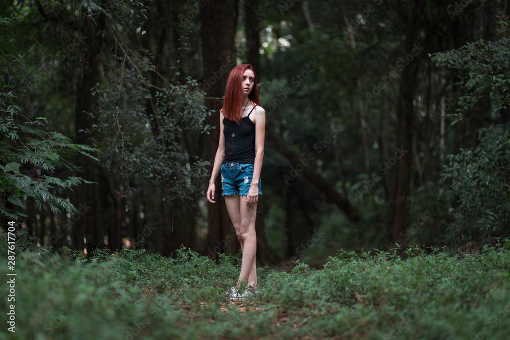a skinny redhead girl in a brazilian forest