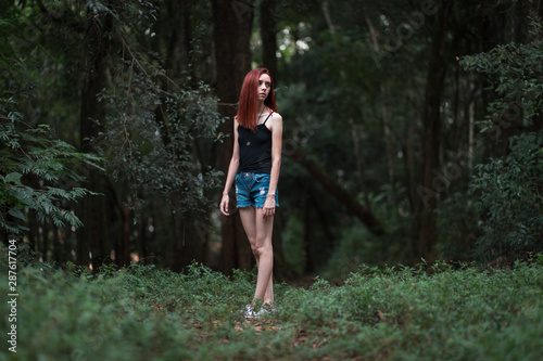 a skinny redhead girl in a brazilian forest