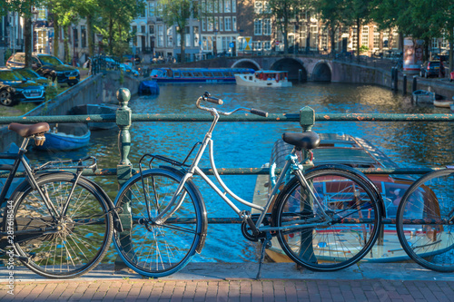 Amsterdam, North Holland / Netherlands - June 22nd, 2019: Bicycles parked along a bridge over the canals © Manel Vinuesa
