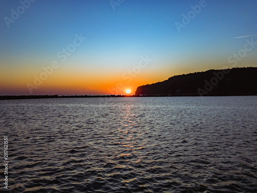 Colorful sunset over the Black Sea coast with ripples on the sea surface on a summer evening with a blue cloudless sky. Научиться произносить Открыть Google Переводчик Оставить отзыв Все результаты 