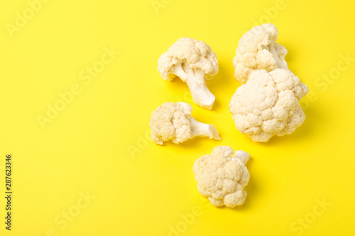 Vegetarian healthy food concept, dieting. Fresh white cleaned cauliflower on yellow background.