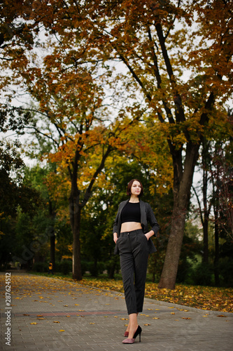 A tall leggy young beautiful and elegant model woman at formal wear posed at autumn background. © AS Photo Family