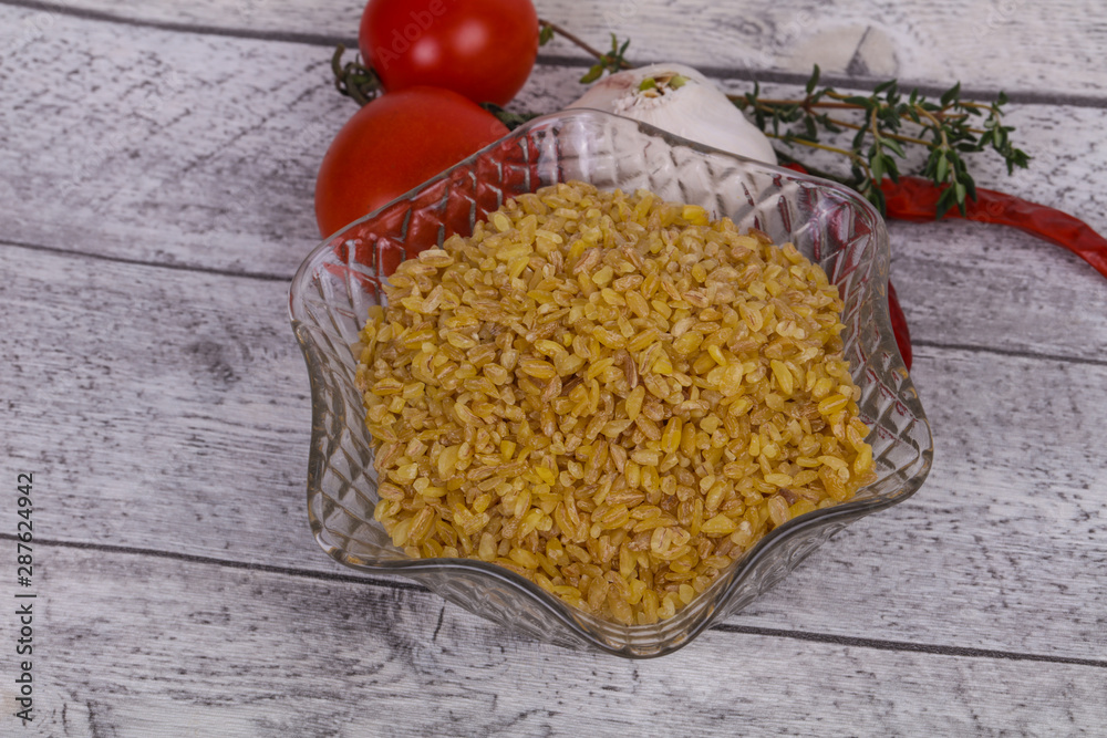 Raw bulgur in the bowl with tomatoes and garlic Raw bulgur in the bowl with tomatoes and garlic