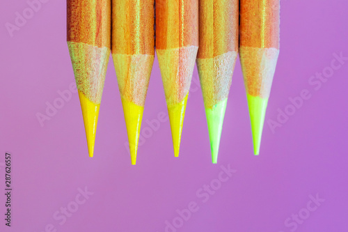 Colored pencils close-up in a trendy neon light. The concept of artistic accessories, creativity. Place for text, minimalism.