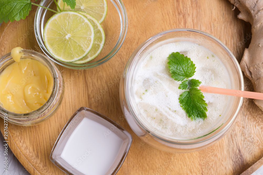 fresh vegetarian banana - ginger cocktail on wooden tray with fresh bananas, lime, melissa and coconut milk . close up. flat lay fresh vegetarian banana - ginger cocktail on wooden tray with fresh bananas, lime, melissa and coconut milk . close up. flat lay