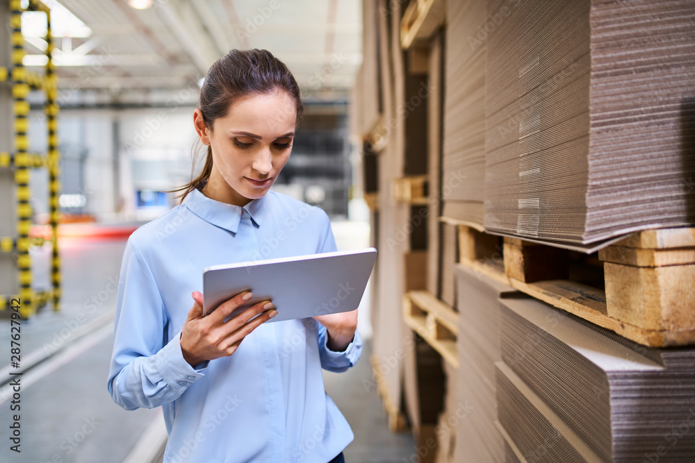 Businesswoman using tablet in a factory warehouse Businesswoman using tablet in a factory warehouse