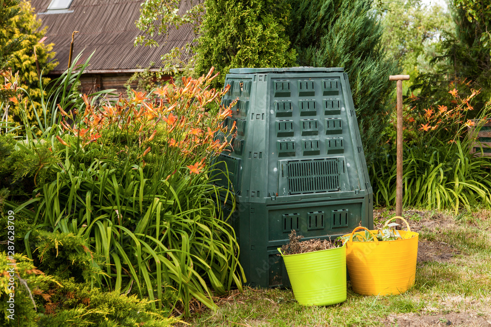 Fotografie Compost bin and mulch in a summer garden