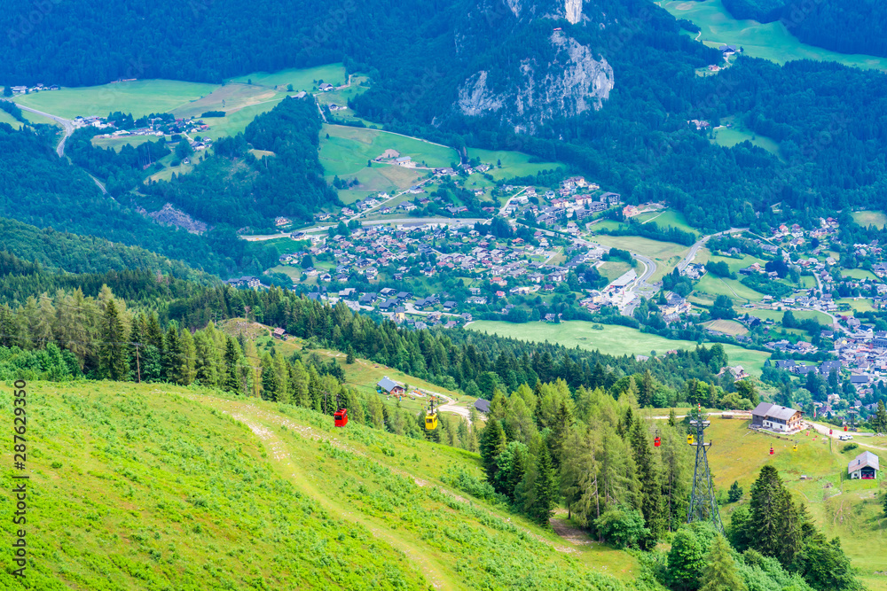 View of St.Gilgen and colorful Seilbahn cable car gondolas against mountains in Salzkammergut region from Zwolferhorn mountain, Austria