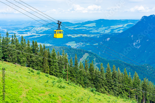 View of yellow Seilbahn cable car gondola against mountains in Salzkammergut region from Zwolferhorn mountain in St.Gilgen, Austria