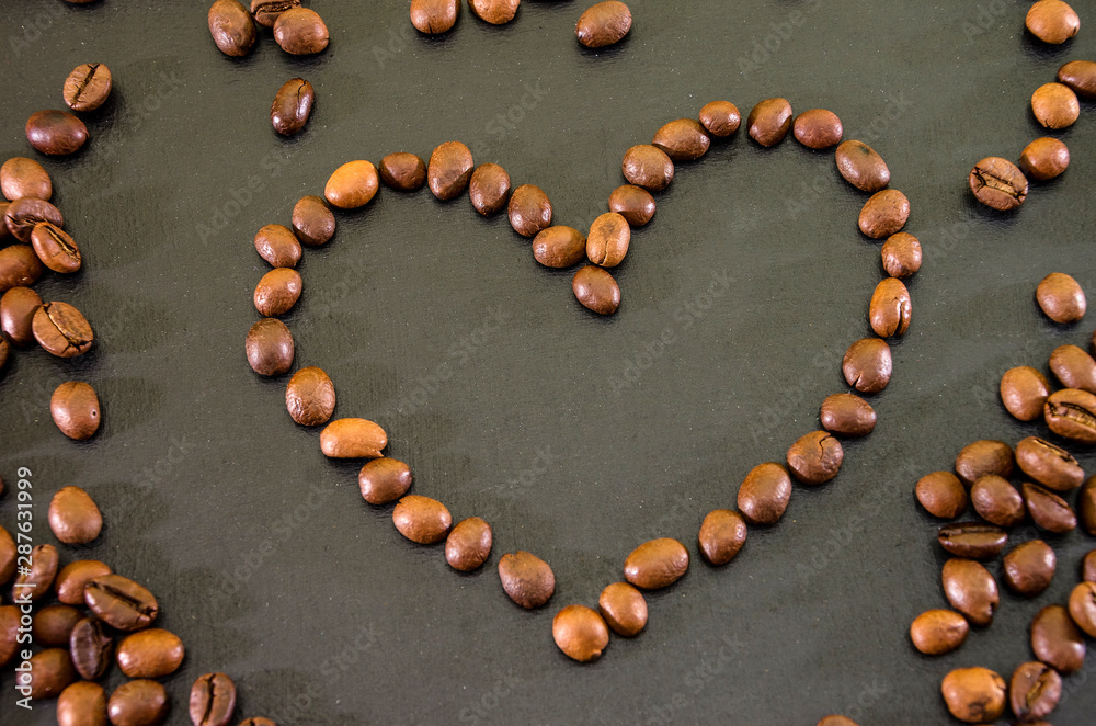 Heart made using coffee beans on a black background
