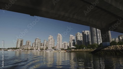 Passing under bridge in Vancouver False Creek with Yaletown in background - smooth shot from moving boat, Canada photo