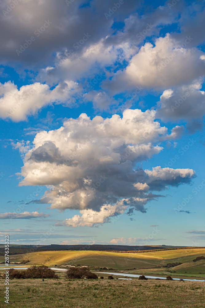 Fluffy clouds over the Cuckmere River in South Downs in Sussex, on a sunny summers evening Fluffy clouds over the Cuckmere River in South Downs in Sussex, on a sunny summers evening