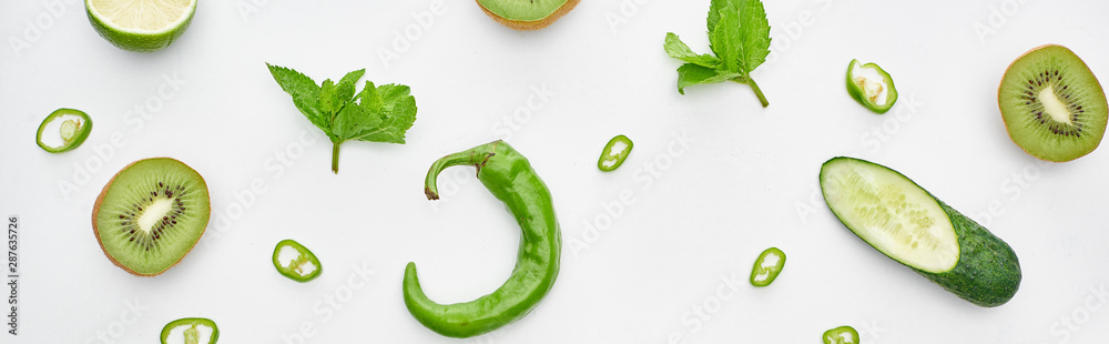 panoramic shot of fresh cucumber, kiwi, lime, peppers and greenery panoramic shot of fresh cucumber, kiwi, lime, peppers and greenery