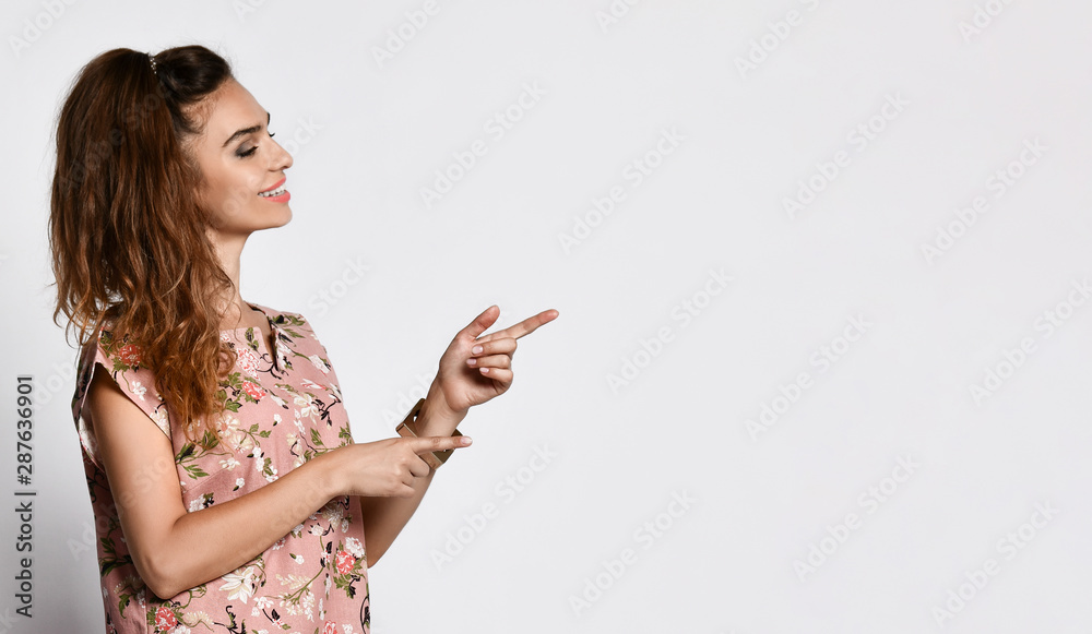 Young emotional long-haired woman posing in a new floral pink fashionable dress, happy full body smiles on a white background. Young emotional long-haired woman posing in a new floral pink fashionable dress, happy full body smiles on a white background.