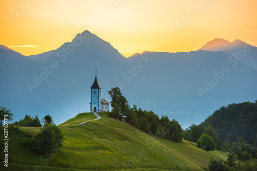 saint primož Church on the hill at sunrise. Beautiful scenery at Jamnik, Slovenia. Panoramic view of the mountains behind the church