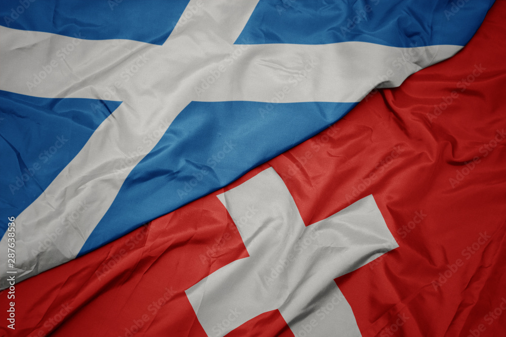 waving colorful flag of switzerland and national flag of scotland. waving colorful flag of switzerland and national flag of scotland.