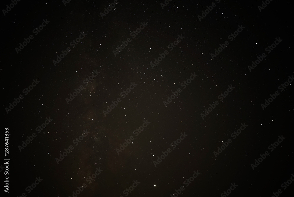 Night starry sky and man with lamp. Long exposure photography.