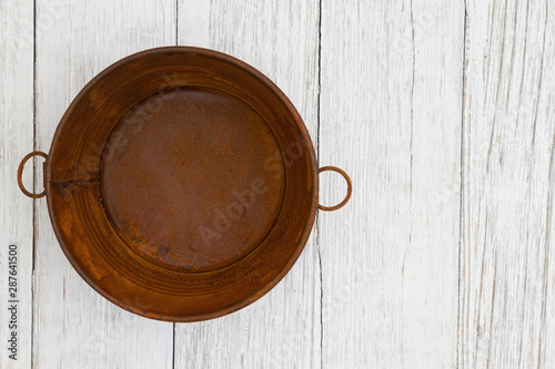 Rusted tin pail on weathered whitewash textured wood background