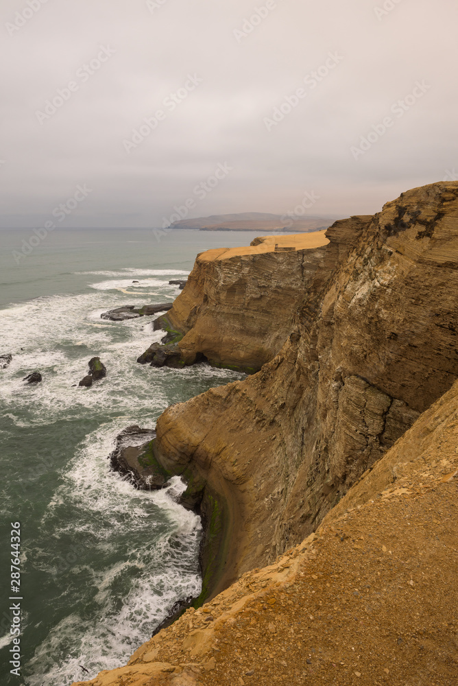 Dramatic coastline with intense colors in the desert of Paracas National Reserve, Peru