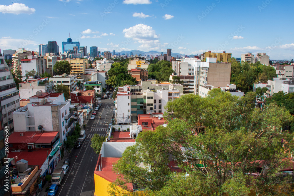 Fototapeta premium Vista panorámica desde las alturas de los edificios de la Ciudad de México con el Worl Trade Center al fondo, de día con cielo azul