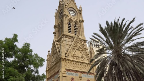 Karachi Merewether Clock Tower Low Angle Side View at JInnah Road with Flying Birds on a Cloudy Day photo