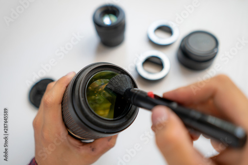 top view of a master repair modern camera equipment, cleaning dust on the lens © Mihail