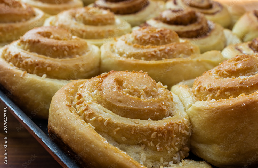 Twisted buns made of yeast dough with cinnamon, cane sugar and coconut, close-up, top side view