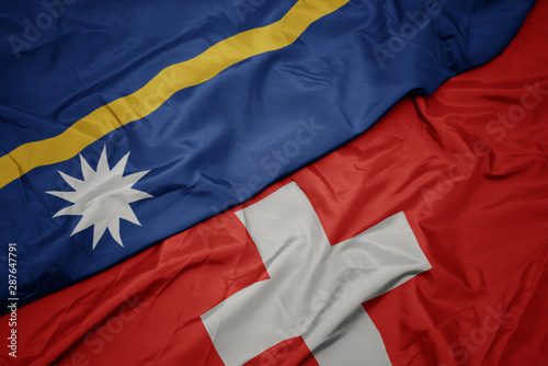 waving colorful flag of switzerland and national flag of Nauru . © luzitanija