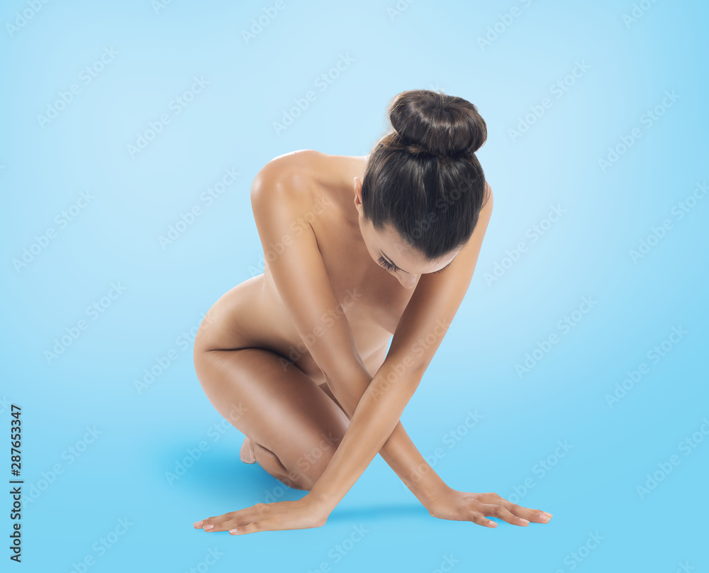 Obraz premium Naked beauty girl poses on blue background