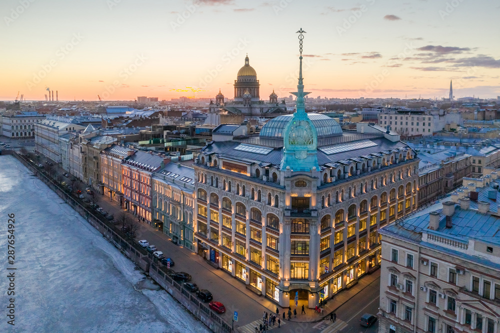 ST. PETERSBURG, RUSSIA - MARCH, 2019: Department store shop class luxury, near the Red Bridge. In the background the city and St. Isaac's Cathedral, in the evening at sunset