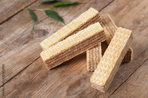 Delicious crispy wafer sticks on brown wooden background