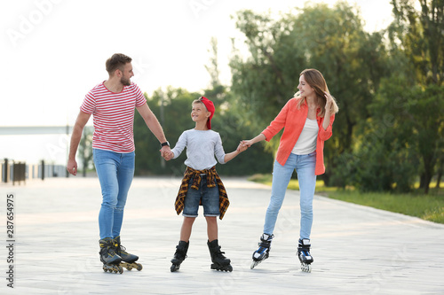 Happy family roller skating on city street